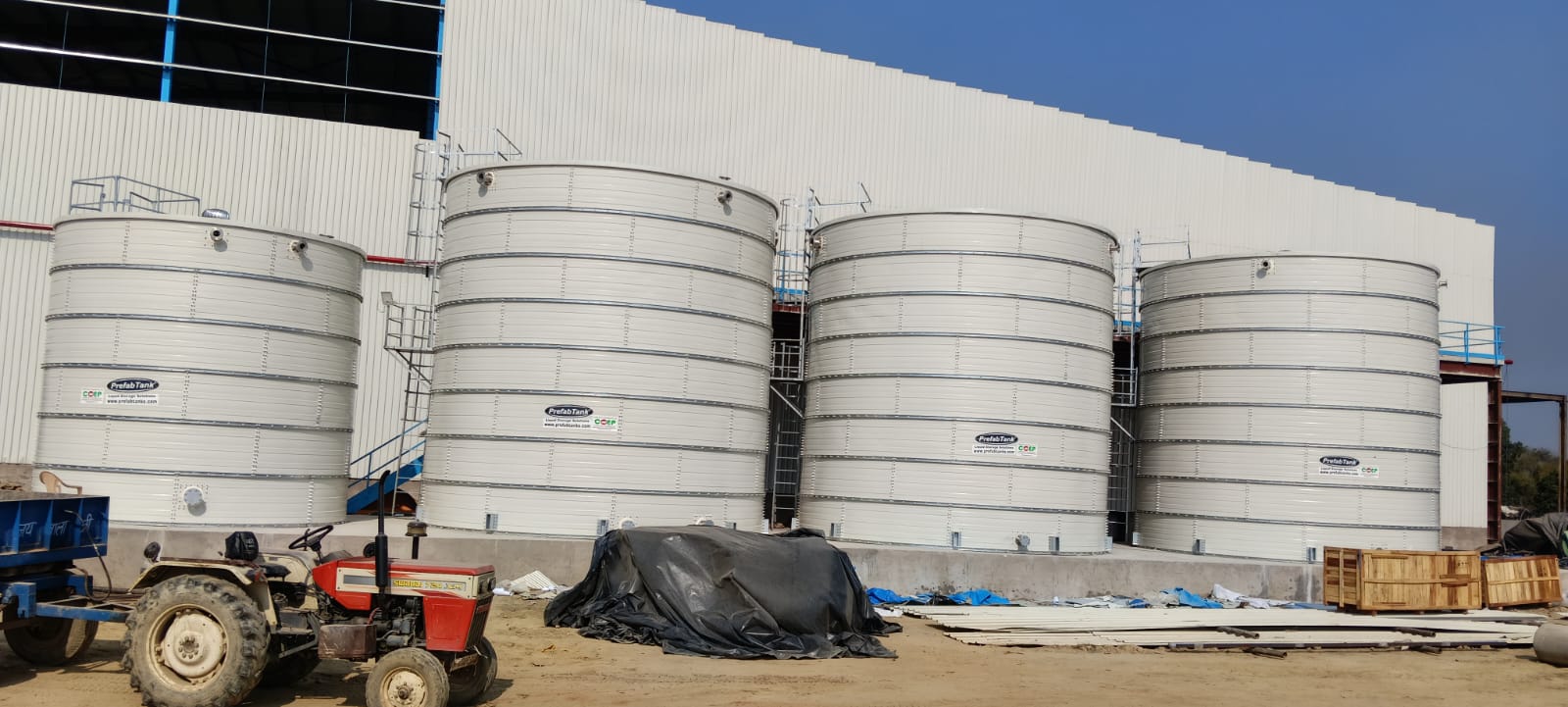 White Zinc Aluminium Steel tank at a hillside site with lush green backdrop