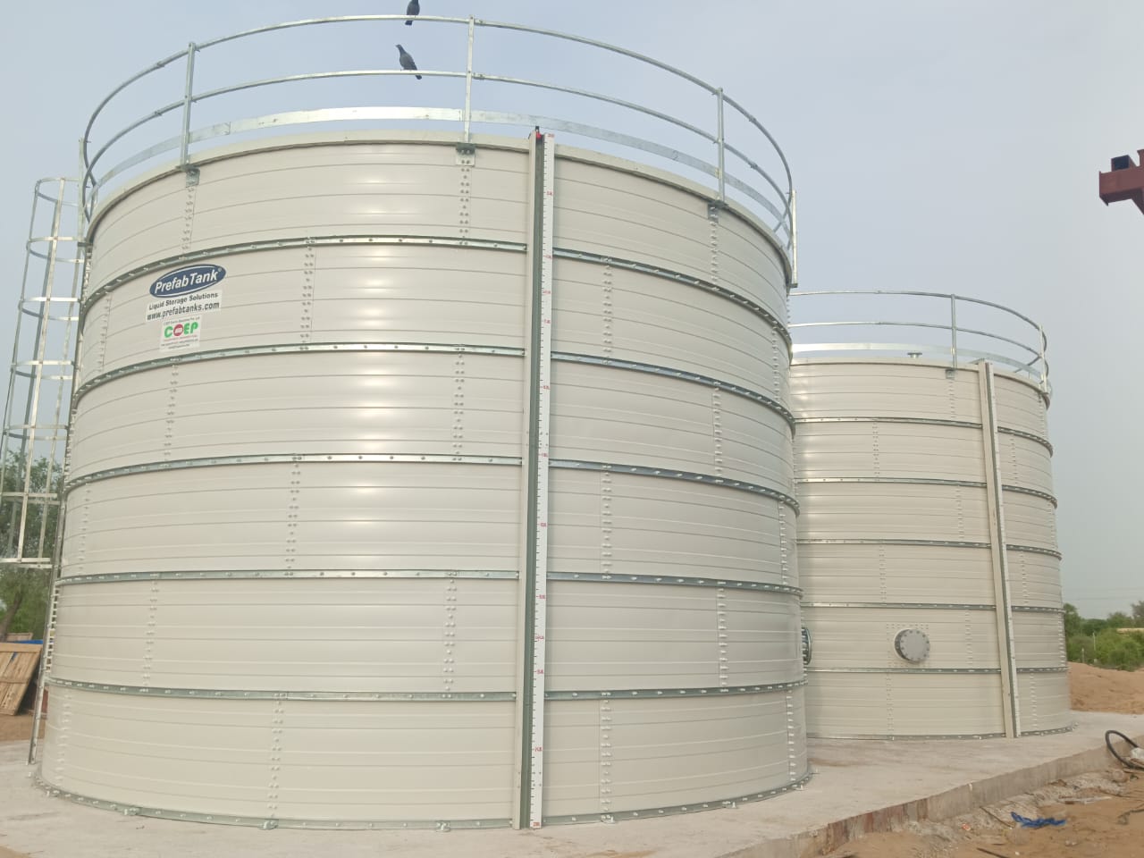 Close view of white Zinc Aluminium Steel tanks with railings and level indicator