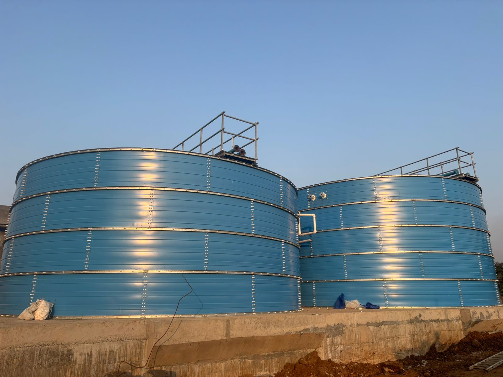 Blue Zinc Aluminium Steel tanks installed outdoors during golden hour