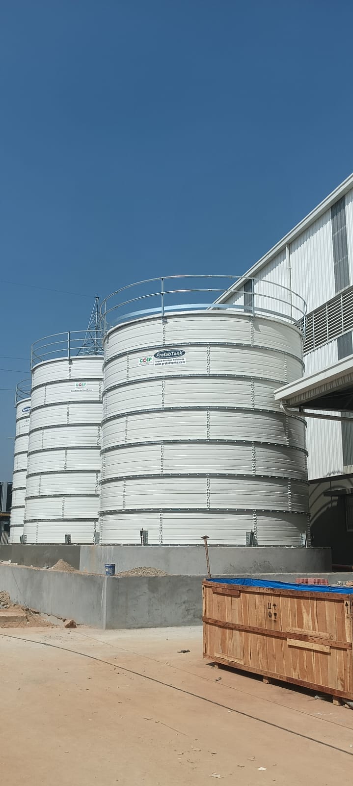 White Zinc Aluminium Steel tanks installed beside a factory wall