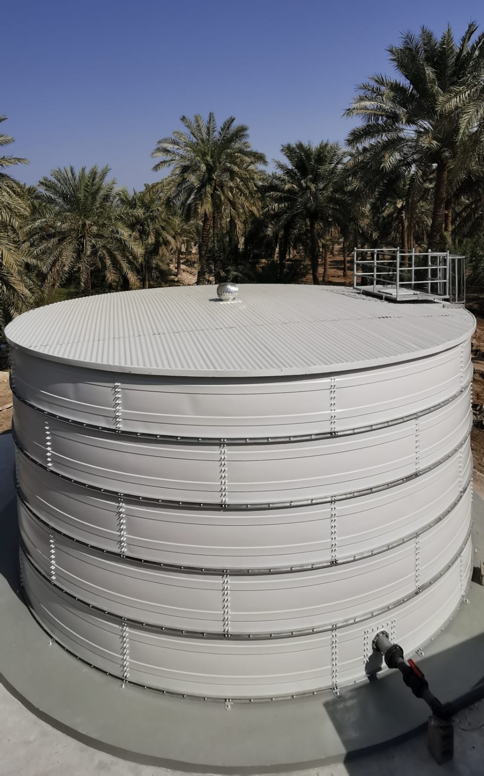 Large Zinc Aluminium Steel tank behind a fenced project site